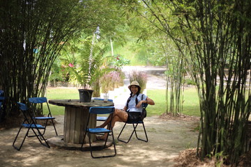 Woman sitting in a bamboo garden in Rayong, Thailand