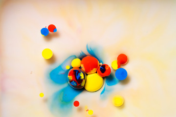 Abstract acrylic paint drops on a colorful background.