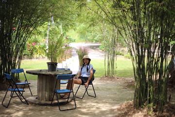 Woman sitting in a bamboo garden in Rayong, Thailand