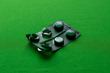 photo open green pack of pills lies on a green background