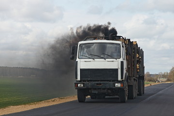 Black smoke from the exhaust pipe of a diesel timber truck, harmful emissions from vehicles ecologe problem