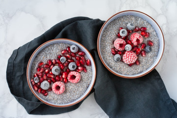 Bunte Chia-Pudding-Bowl als Frühstück mit frischem Obst und Beeren wie Himbeeren, Heidelbeeren...