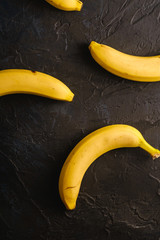 Banana fruits on dark textured background, top view