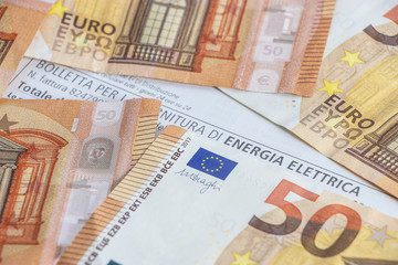 Banconote da 50 euro sopra una fattura di energia elettrica
