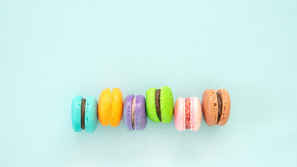 Colorful macarons dessert on blue background.