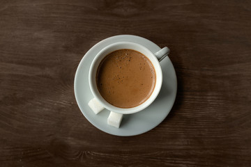 Cup of coffee on the table. Spoon, white Cup and saucer