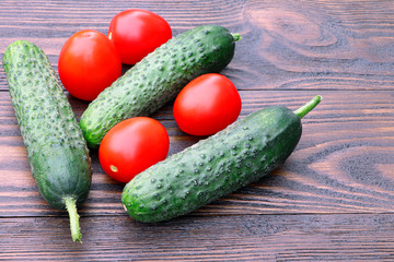 Tomatoes and cucumbers on a wooden table. Organic, raw vegetables. Vegan, healthy food