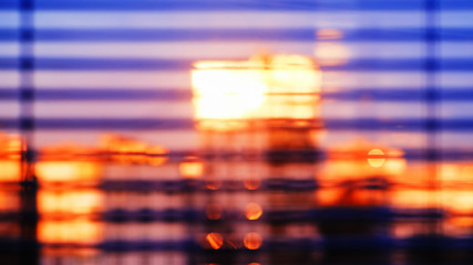 Background, blur, out of focus, bokeh. The soft sunlight of the setting sun is reflected in the Windows of city houses. View from the window, through the sun blinds.