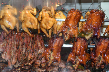 Roasted ducks hanging on rack showcase