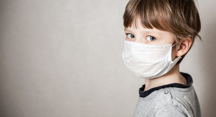 Boy in medical mask. Coronavirus COVID-19 lockdown, panic. Vaccine from new virus