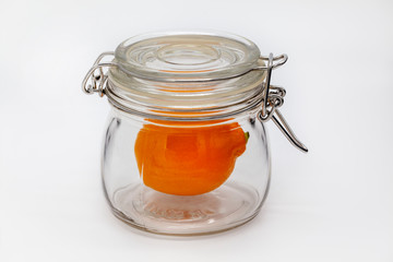 Money saving concept. Meyer, orange, lemon from Uzbekistan, lemon in a glass jar on a white background, isolated