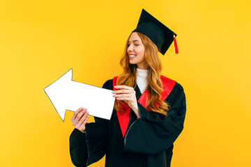 A happy, graduate holds a clean paper layout, pointing to a copy of the space on a yellow background