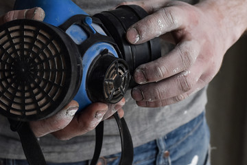 a respirator for filtering dirty air in the hands of a man