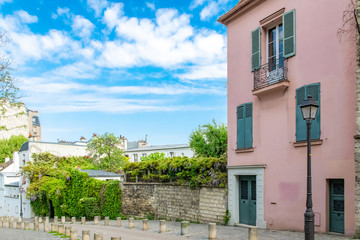 Paris, France, famous pink house and buildings in Montmartre, in a typical street
