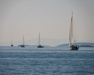 Sailing boats at sea. Sailing yachts sail in the Adriatic Sea against the background of the islands, Croatia.
