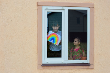 Children from the window show a picture of the rainbow, as a symbol of support during the coronavirus