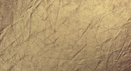 Wrinkled bright gold fabric. Texture background for design