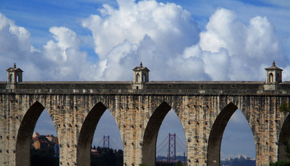 Fototapeta premium Aqueduct Aguas Libres and bridge 25 Abril in the rear. Lisbon. Portugal.