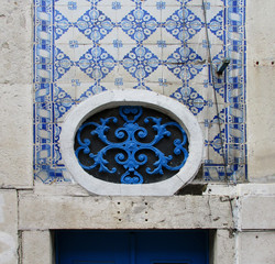 Streets of Lisbon. Detail of traditional colorful tiled facade with window. Portugal. 
