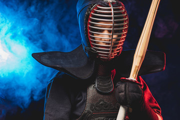 confident kendo fighter in armor practicing with bamboo sword, preparing for competitions. samurai,...