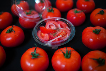Ripe tomatoes on dark wooden background