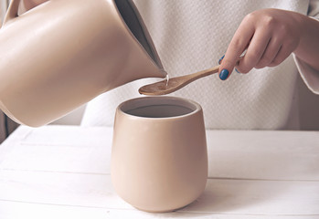 making dalgona coffee. Step 5, step by step visual instruction how to make korean trendy fluffy coffee drink. pour hot water into a mixing jar. Woman's hand holding a pitcher with water