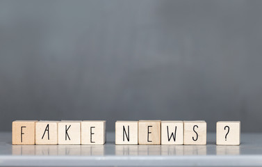 Wooden cubess with the words Fake News on grey background, Fake News concept social media