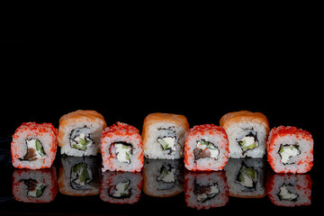 Philadelphia roll with salmon, cheese and cucumber on a black background with reflection. Sushi Philadelphia