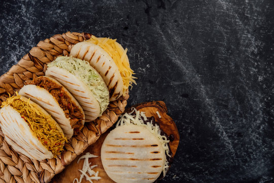 Top view of various types of typical Venezuelan arepas in a woven basket