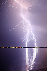 Lightning strike reflecting in water surface.  