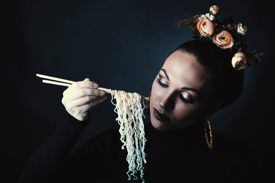 Beautiful girl eats noodles doshirak.
Studio photography, filter stylized photography
