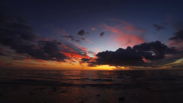 Sea surf on the night beach. Dark sunset over tropical sea