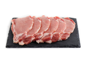 uncooked meat isolated on white. Pieces of pork on black plate