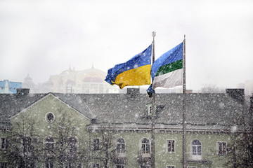 Snowfall in the Rivne city with national flag