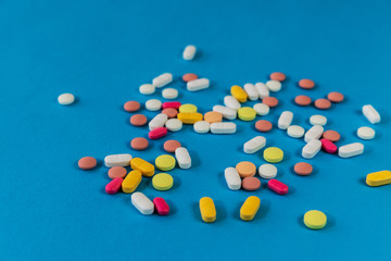Different medicine pills, tablets on blue background. Many pills and tablets with space for text. Health care. Top view. Copy space. New image. Pharmaceutical picture. Closeup. Close-up. Soft focus