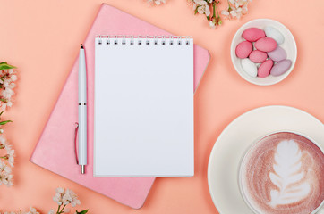 Creative flat lay of workspace desk, notepad for wishlist and lifestyle objects on pink background