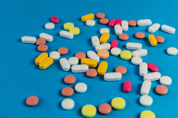 Different medicine pills, tablets on blue background. Many medicine pills and tablets. Health care. Top view. Copy space. New image. Pharmaceutical pills. Closeup. Soft focus.