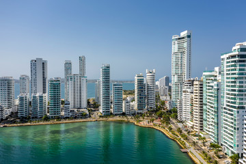 Obraz na płótnie Canvas Aerial view of a skyline of white residential skyscrapers in Cartagena's prestigious Castillogrande district.