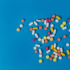Different medicine pills, tablets on blue background. Many pills and tablets with space for text. Health care. Top view. Copy space. New image. Pharmaceutical picture. Nice flatlay. Good background