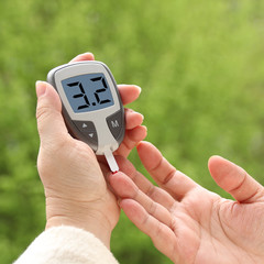 close-up female hands, woman makes test with lancet pen and glucometer, Medicine, glycemia, healthcare and medical concept