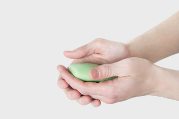 Washing hands with soap isolated on white background close-up. Man holds a bar of soap in his hands. Please wash your hands concept
