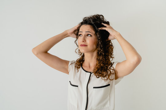Chica joven tiene un problema, tienes las manos en la cabeza y una cara muy expresiva