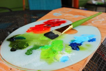 Obraz premium Colorful Oil Paint Palette After Painting with Green Paintbrush