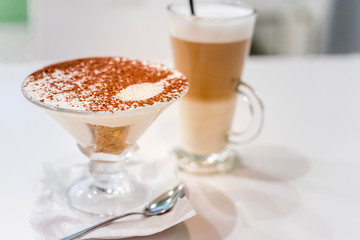 coffee latte with frothy milk in tall glass, rustic style, white background
