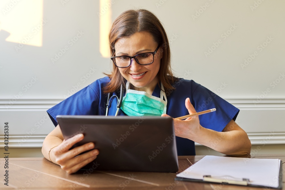 Wall mural female doctor counseling, helping patient online, medic using digital tablet for video call