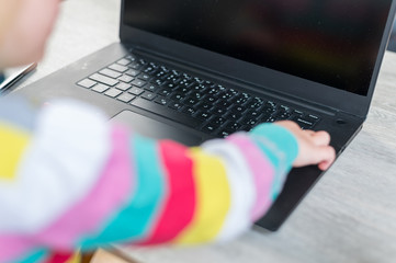 Side view of blonde girl using laptop computer.