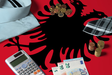 Albania flag on minimal money concept table. Coins and financial objects on flag surface. National economy theme.
