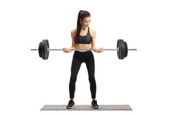 Fototapeta na wymiar Young woman in sportswear lifting weights