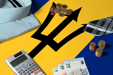 Barbados flag on minimal money concept table. Coins and financial objects on flag surface. National economy theme.