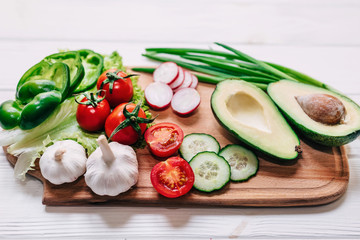 Ingredients for making salad on rustic white chalk board background. Healthy, clean eating concept. Vegan or gluten free diet.